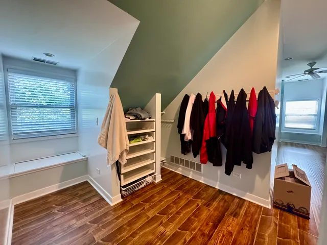 a view of walk in closet with clothes and shoes