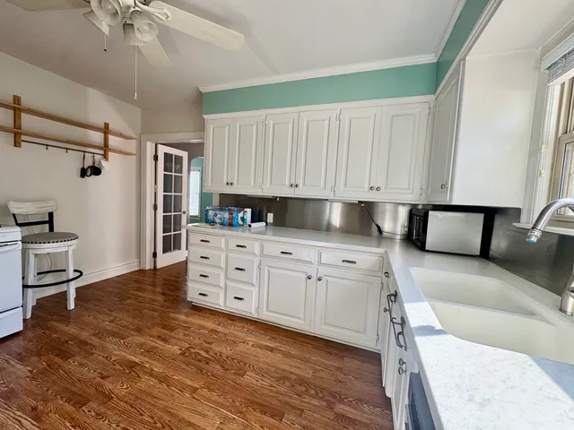 a kitchen with granite countertop a sink cabinets stainless steel appliances and a counter top space