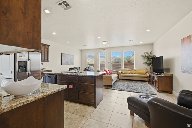 4269 Razor Drive Washington, UT 84780 - Photo 47 of 50 Kitchen with light stone counters, open floor plan, light tile patterned flooring, dark brown cabinetry, and recessed lighting