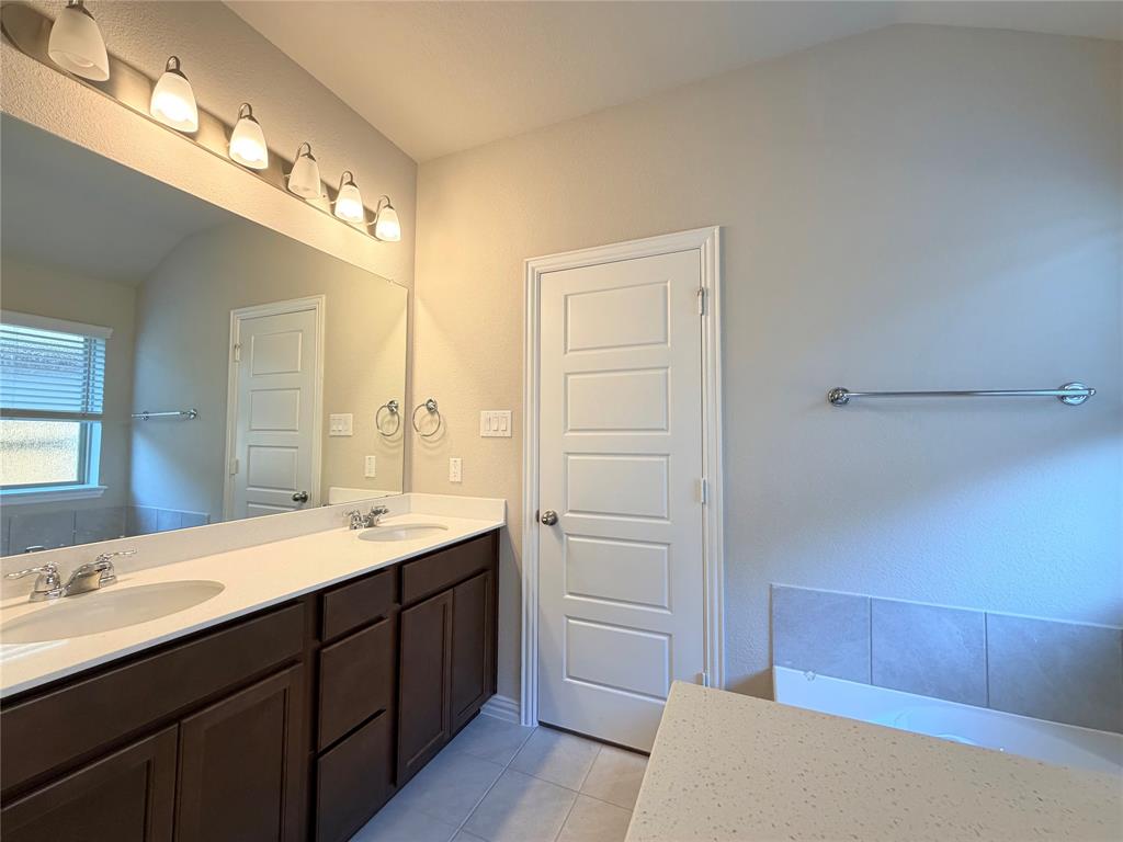 5401 Inwood Drive Denton, TX 76207 - Photo 15 of 21 a bathroom with a double vanity sink a mirror and a shower