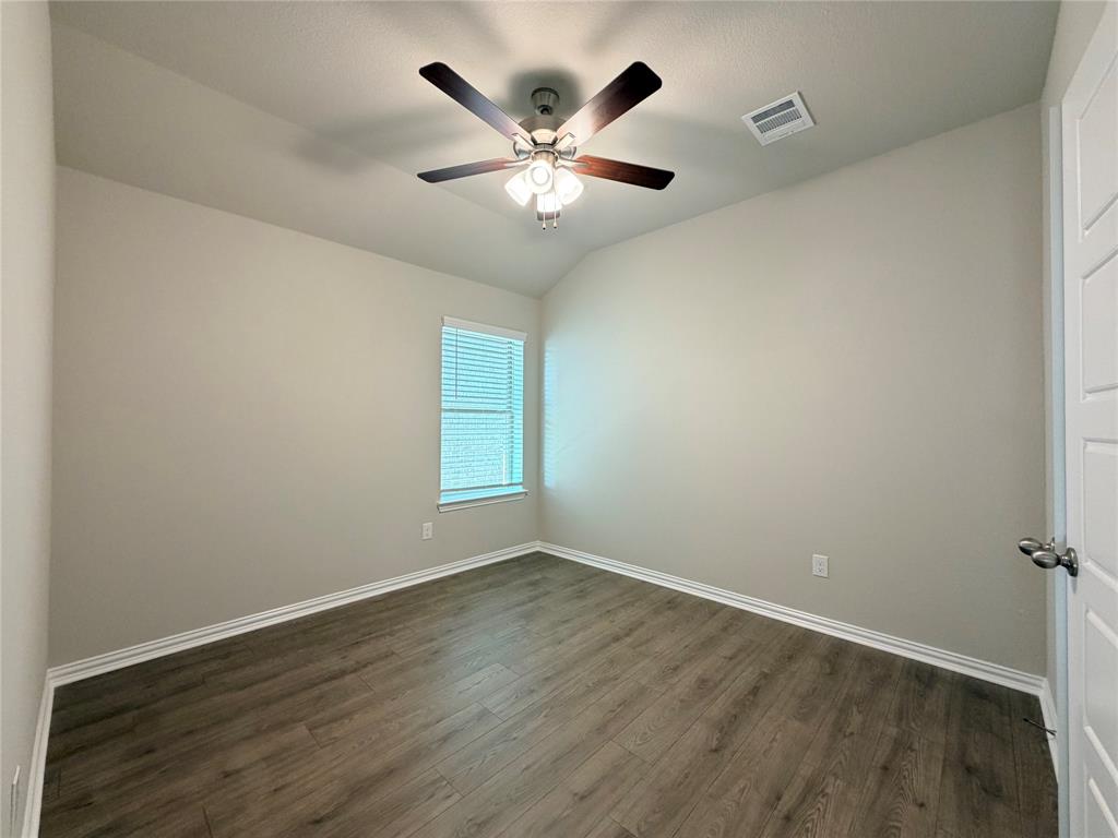 5401 Inwood Drive Denton, TX 76207 - Photo 18 of 21 an empty room with wooden floor and ceiling fan