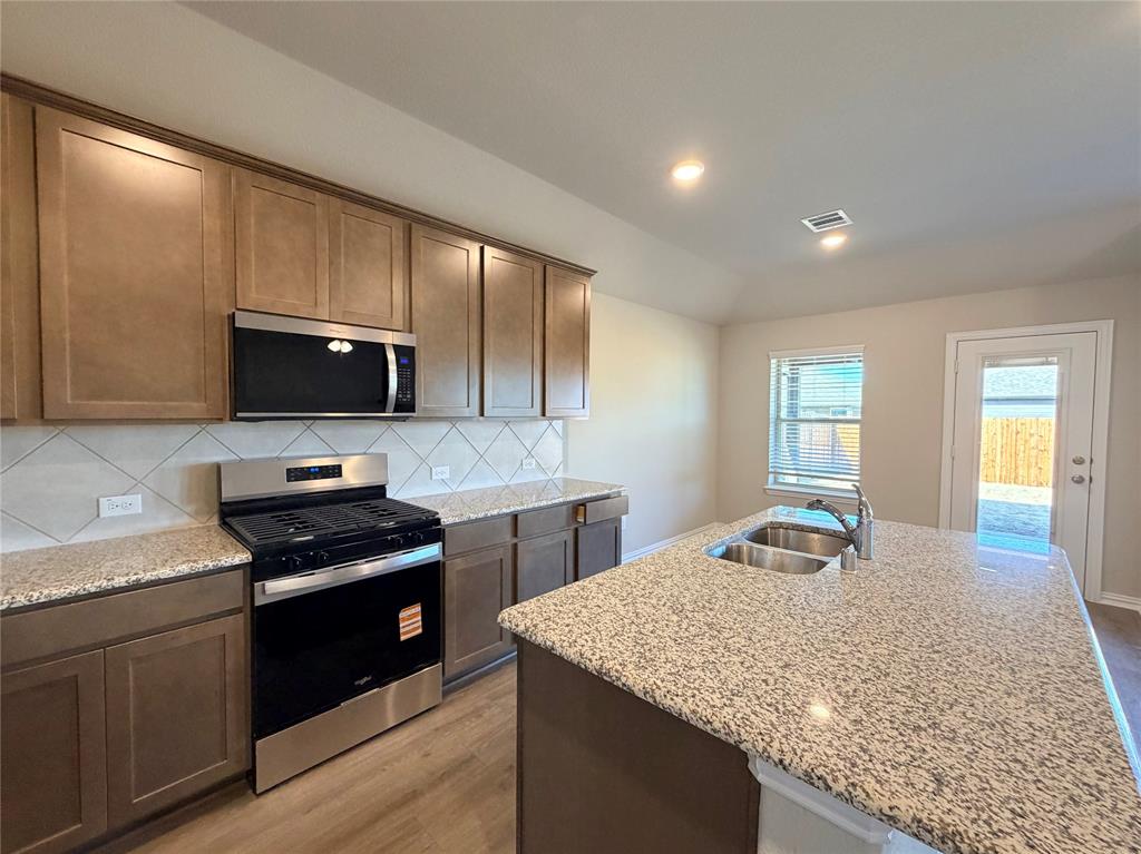 5401 Inwood Drive Denton, TX 76207 - Photo 8 of 21 a kitchen with stainless steel appliances granite countertop a sink stove and microwave