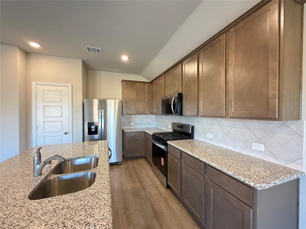 5401 Inwood Drive Denton, TX 76207 - Photo 9 of 21 a large kitchen with stainless steel appliances granite countertop a sink refrigerator and cabinets
