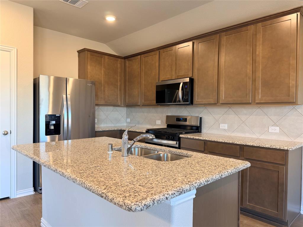 5401 Inwood Drive Denton, TX 76207 - Photo 10 of 21 a kitchen with granite countertop a sink a counter top space cabinets stainless steel appliances and a counter space