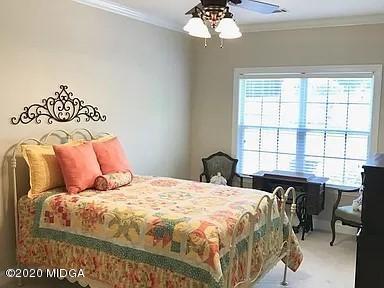 9743 Lower Thomaston Road Macon, GA 31220 - Photo 17 of 28 a bedroom with a large bed and a chandelier