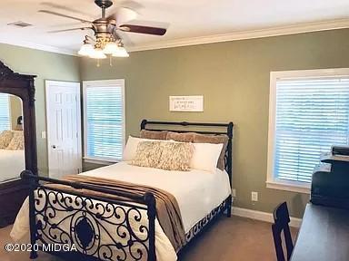 9743 Lower Thomaston Road Macon, GA 31220 - Photo 20 of 28 a bedroom with a large bed and a chandelier