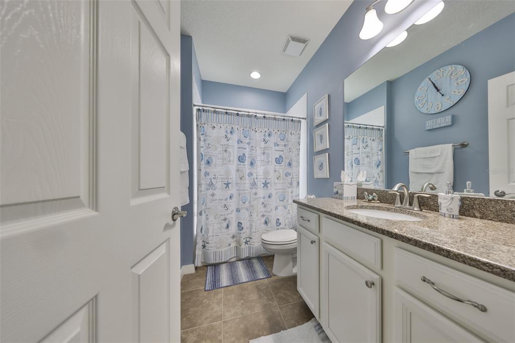 511 Winterside Drive Apollo Beach, FL 33572 - Photo 34 of 74 a spacious bathroom with a granite countertop sink toilet mirror and a shower