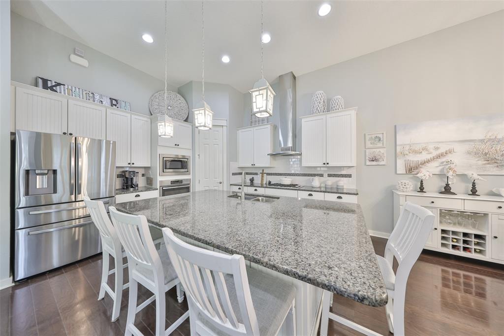 511 Winterside Drive Apollo Beach, FL 33572 - Photo 5 of 72 a kitchen with stainless steel appliances granite countertop a stove top oven a refrigerator a sink and white cabinets