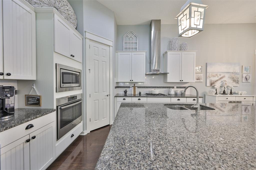 511 Winterside Drive Apollo Beach, FL 33572 - Photo 8 of 72 a large kitchen with granite countertop a sink white cabinets and stainless steel appliances