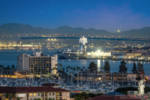 a bathroom with a granite countertop toilet a sink a mirror and a shower