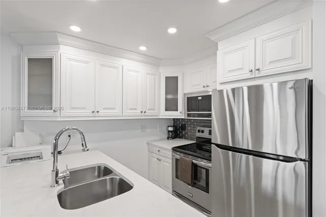 a kitchen with stainless steel appliances granite countertop a refrigerator sink and stove