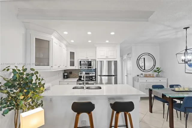 a kitchen with refrigerator a sink and chairs