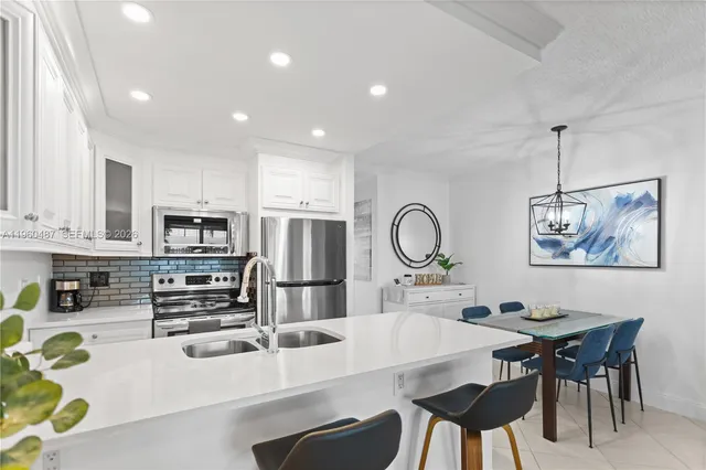 a kitchen with stainless steel appliances a table chairs and a refrigerator