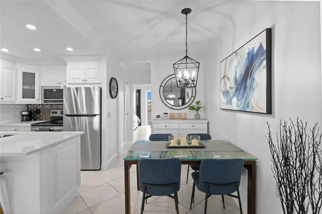 a kitchen with stainless steel appliances kitchen island granite countertop a refrigerator a stove a kitchen island a dining table and chairs