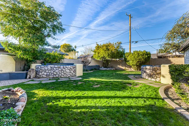a view of a house with a yard and a large tree