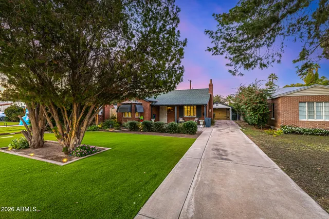 a front view of a house with a garden and trees