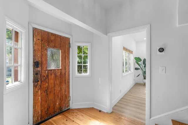 a view of a hallway with wooden floor and windows
