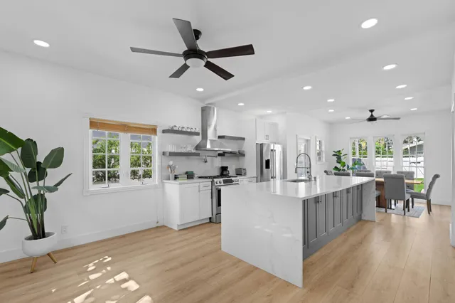 a view of a kitchen with kitchen island wooden floor center island and stainless steel appliances