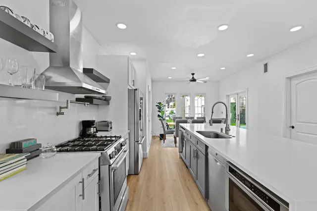 a kitchen with lots of counter top space a stove and wooden floor