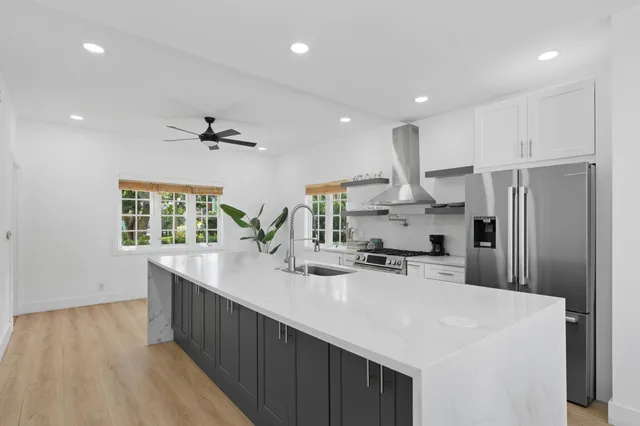 a kitchen with kitchen island a sink appliances and cabinets