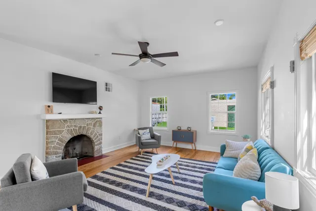 a living room with furniture a fireplace and a flat screen tv