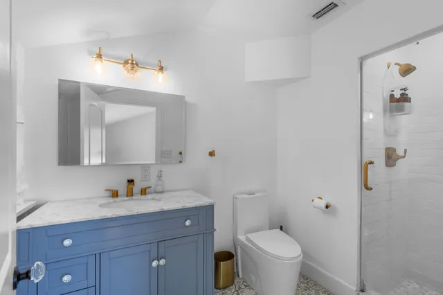 a bathroom with a toilet sink and mirror