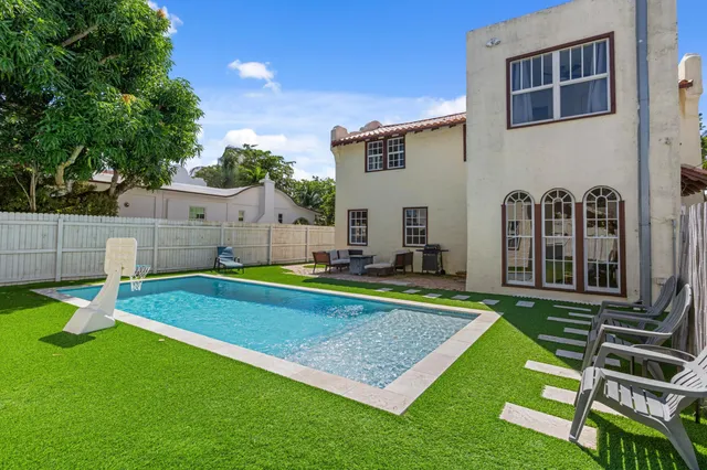 a view of a house with backyard and a swimming pool