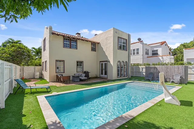 a view of a house with swimming pool and a yard