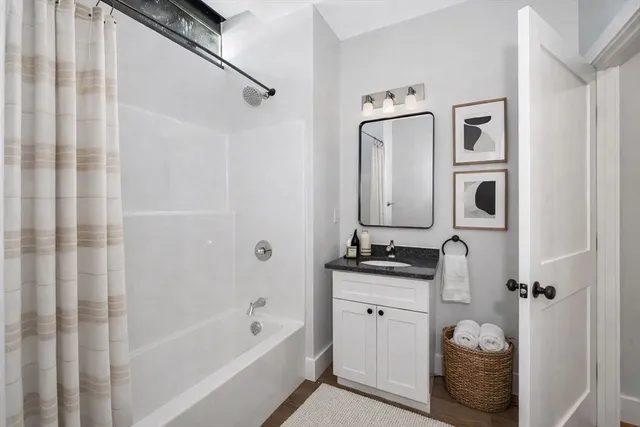 a bathroom with a bathtub sink and mirror