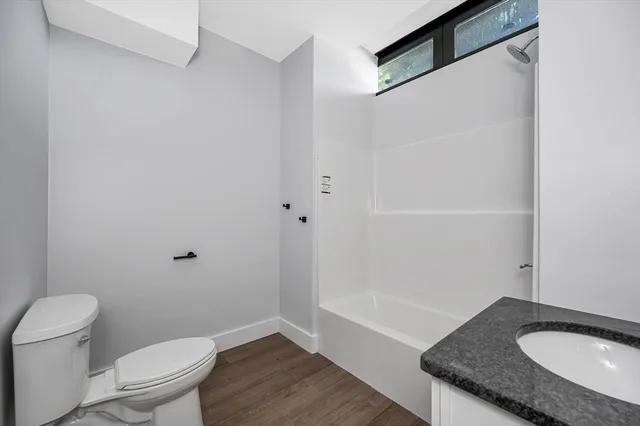 a bathroom with a granite countertop sink toilet and a mirror