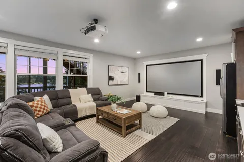 a living room with stainless steel appliances furniture and a wooden floor