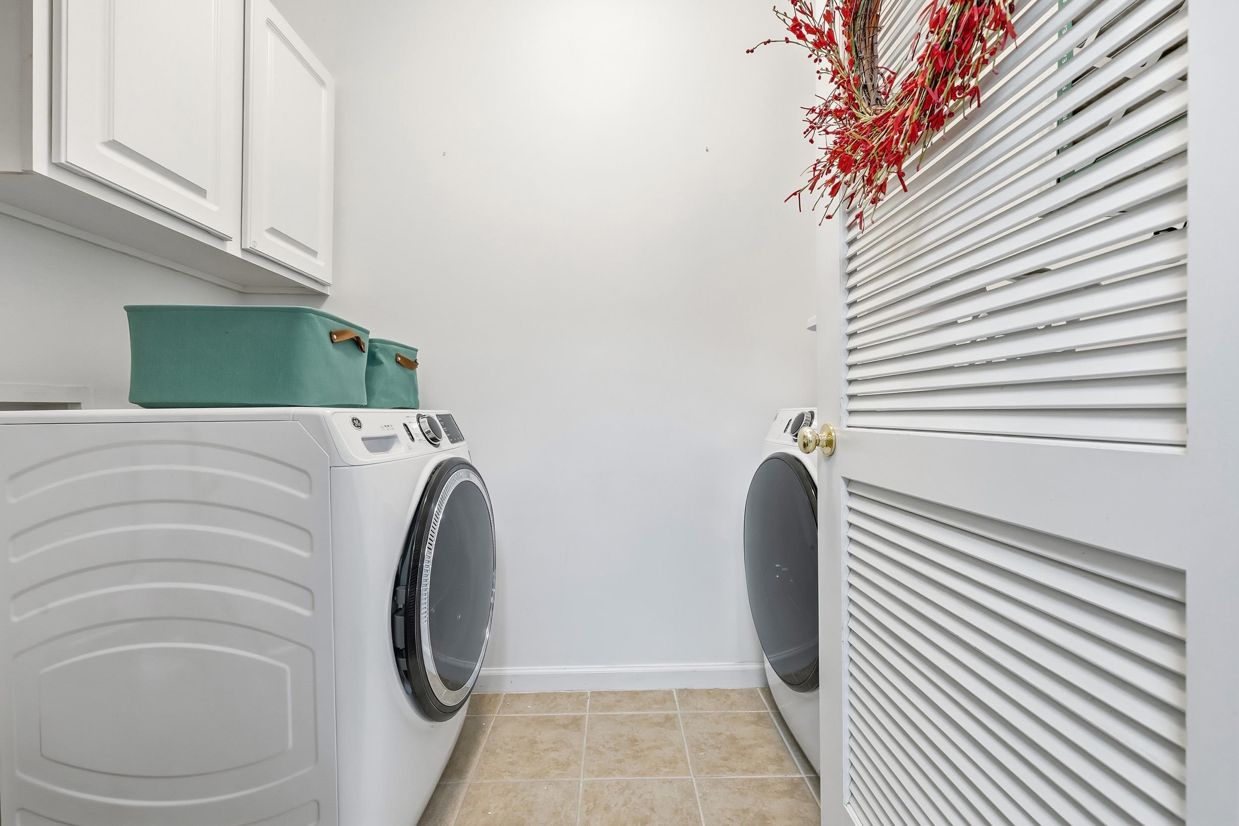 5870 Longwood Drive, Unit 203 Murrells Inlet, SC 29576 - Photo 13 of 32 Laundry room with cabinet space, washing machine and clothes dryer, and light tile patterned flooring