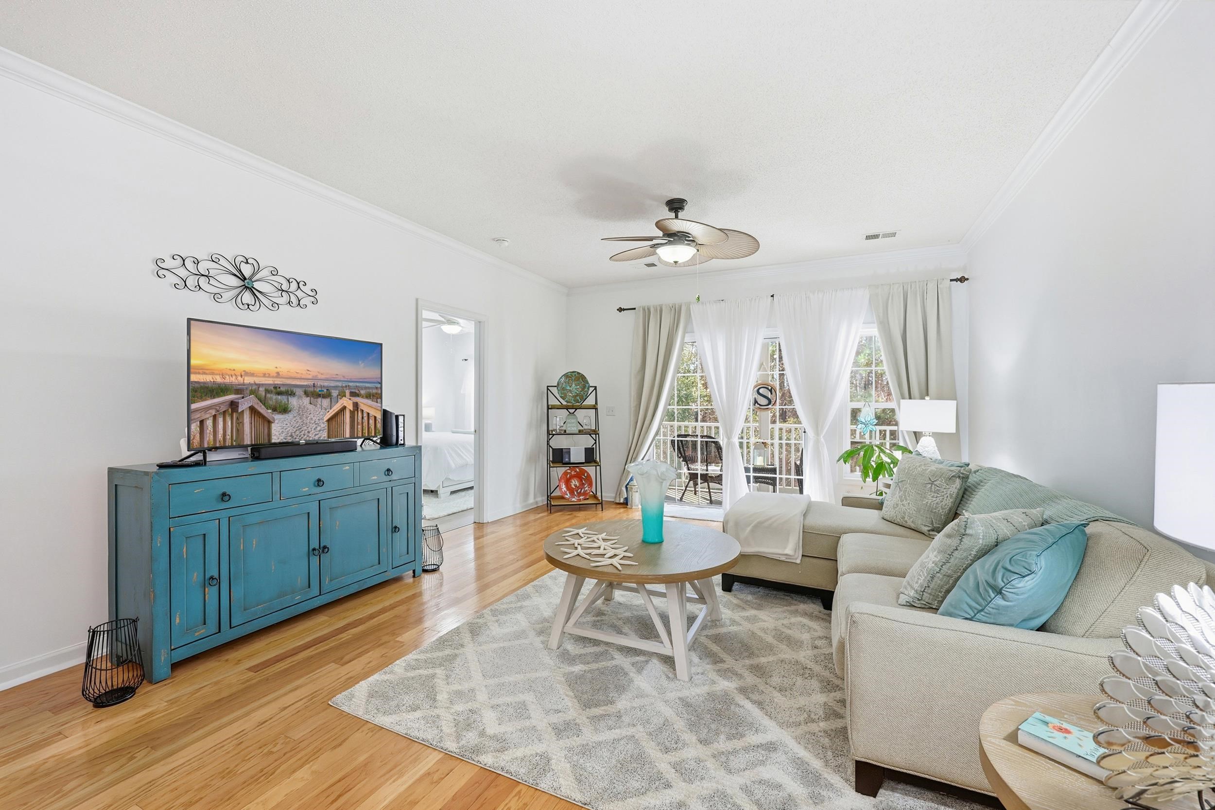 5870 Longwood Drive, Unit 203 Murrells Inlet, SC 29576 - Photo 17 of 32 Living area featuring ornamental molding, light wood-style flooring, and a ceiling fan