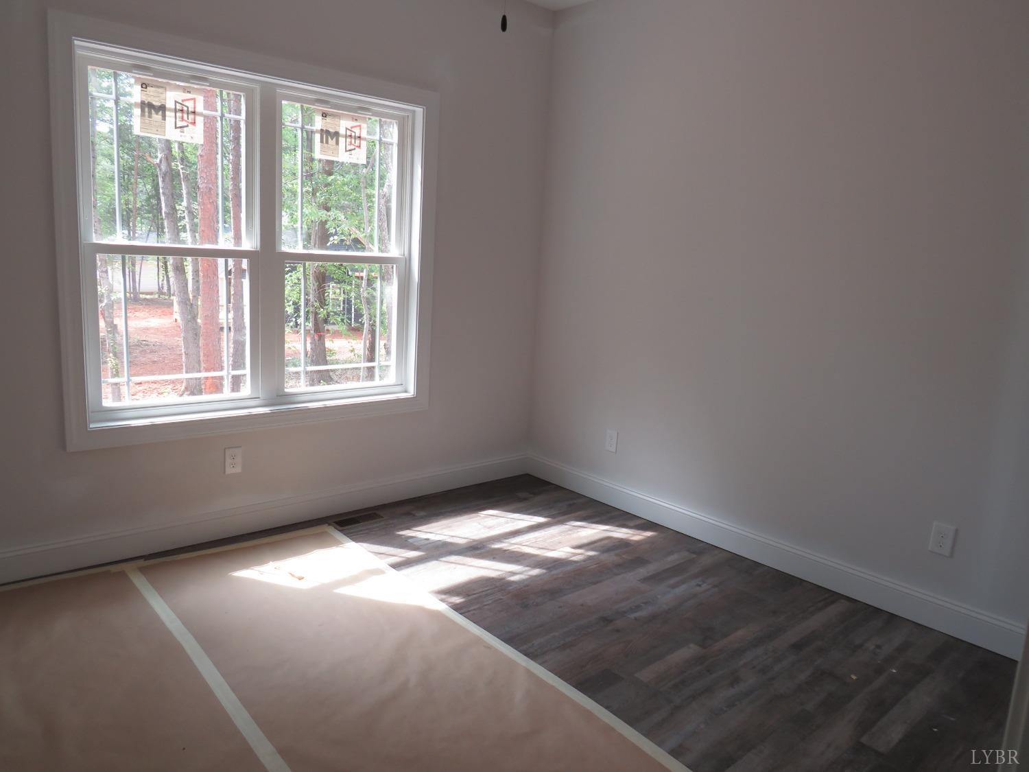 40 Hawkins Road Evington, VA 24550 - Photo 4 of 14 an empty room with wooden floor and windows
