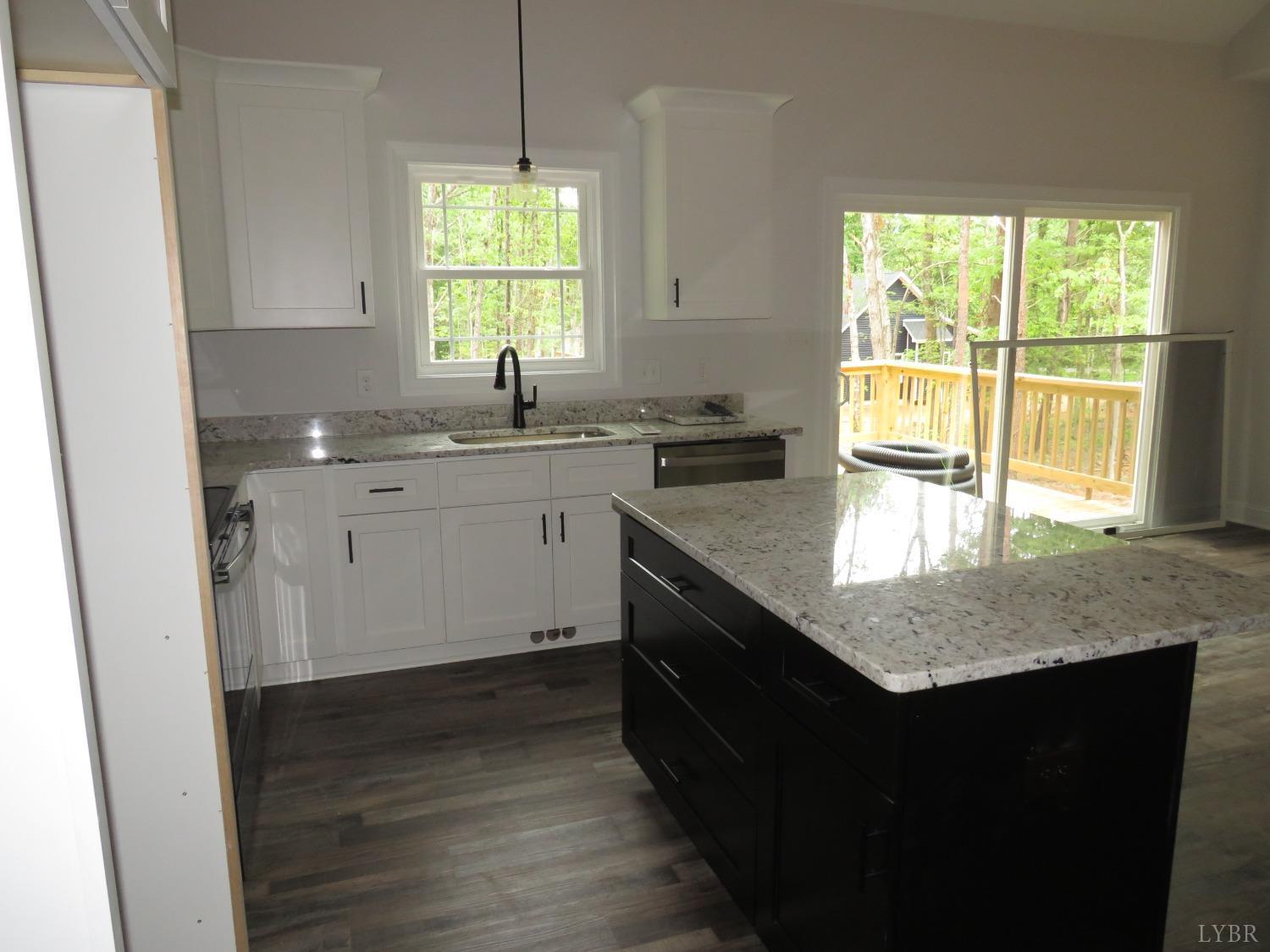40 Hawkins Road Evington, VA 24550 - Photo 9 of 14 a kitchen with granite countertop a sink a window and cabinets