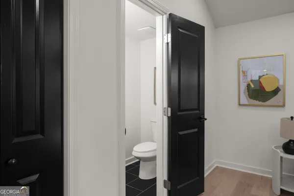 a bathroom with a toilet and a painting on the wall