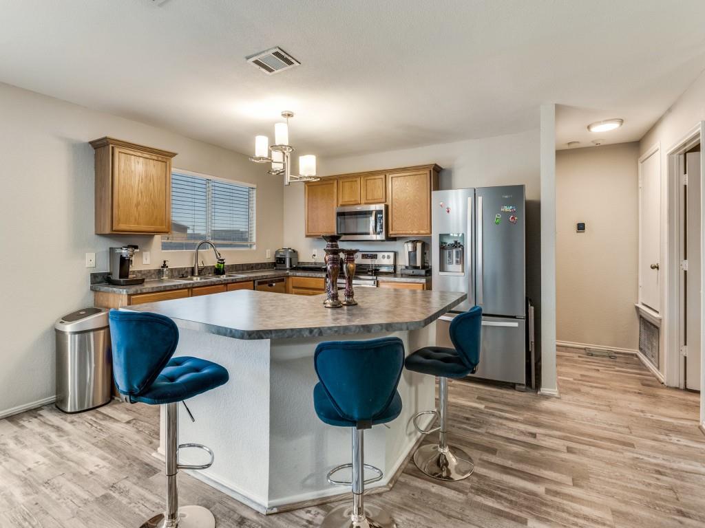 147 Washington Way Venus, TX 76084 - Photo 10 of 24 a kitchen with stainless steel appliances granite countertop a refrigerator a stove a sink cabinets and dining table