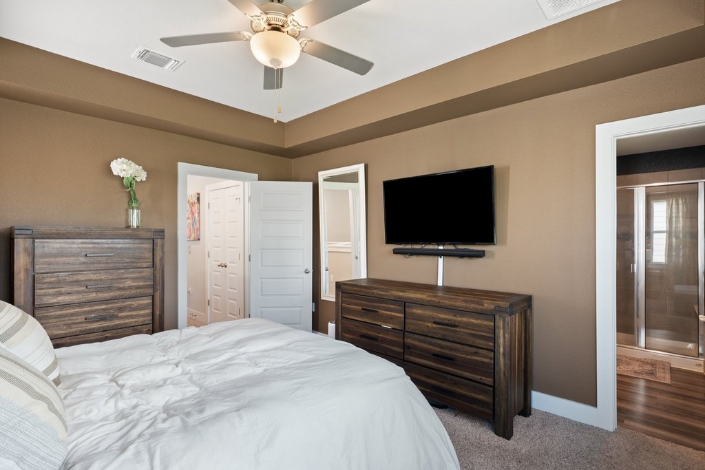 7403 Travertine Spring Drive, Unit 117 Austin, TX 78744 - Photo 21 of 37 Retreat to this primary bedroom offering a tray ceiling and a convenient en-suite bathroom.
