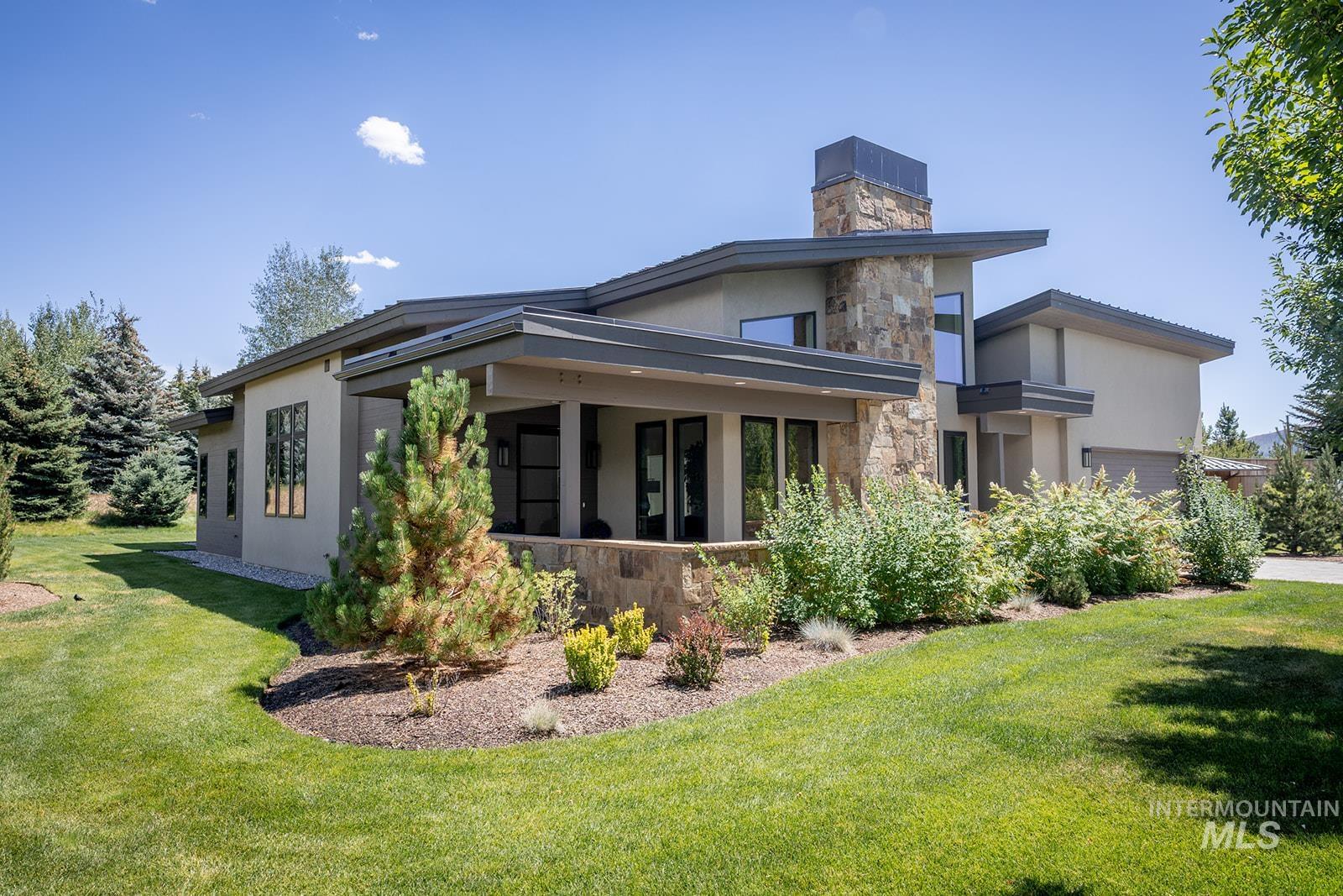 27 Streamside Drive Hailey, ID 83333 - Photo 33 of 39 View of side of property with stone siding, a lawn, stucco siding, and a chimney
