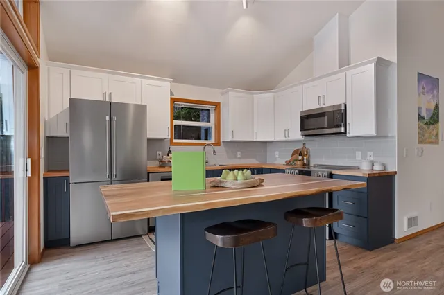 a kitchen with stainless steel appliances a stove refrigerator sink microwave and cabinets