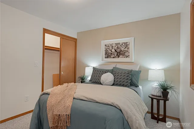a bedroom with a large bed and a potted plant