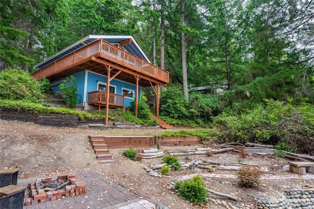 a view of small house with yard and sitting area