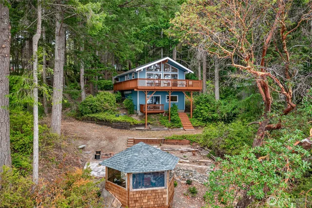 a front view of a house with yard and trees