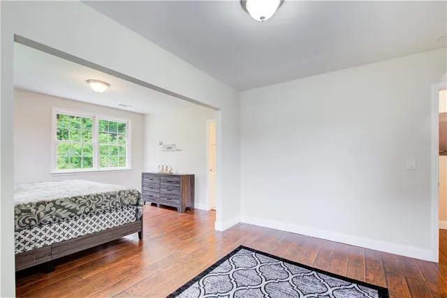 a bedroom with a bed and a dresser next to a window