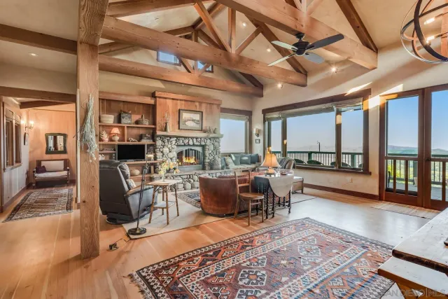 a living room with furniture a large window and a chandelier