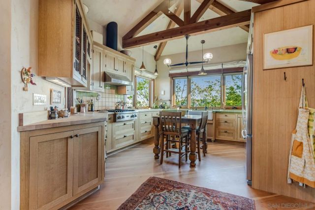 a kitchen with a table chairs refrigerator and cabinets