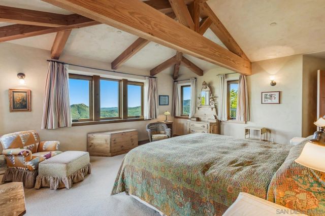 a bathroom with a granite countertop sink a large mirror a toilet and a window