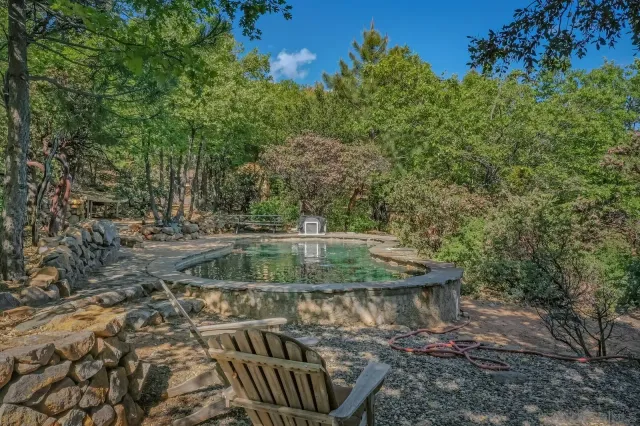 an aerial view of residential house with outdoor space and trees all around