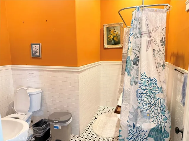 a bathroom with a toilet and a shower curtain
