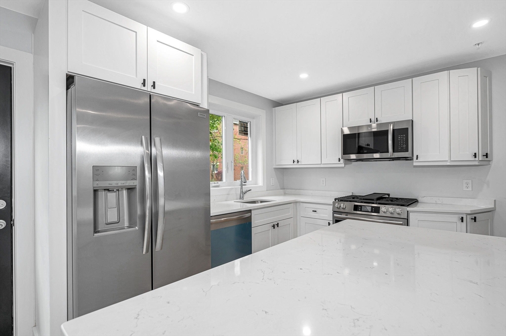 1514 Gorham Street, Unit 4 Lowell, MA 01852 - Photo 11 of 42 a kitchen with stainless steel appliances granite countertop a refrigerator a stove a sink and a microwave